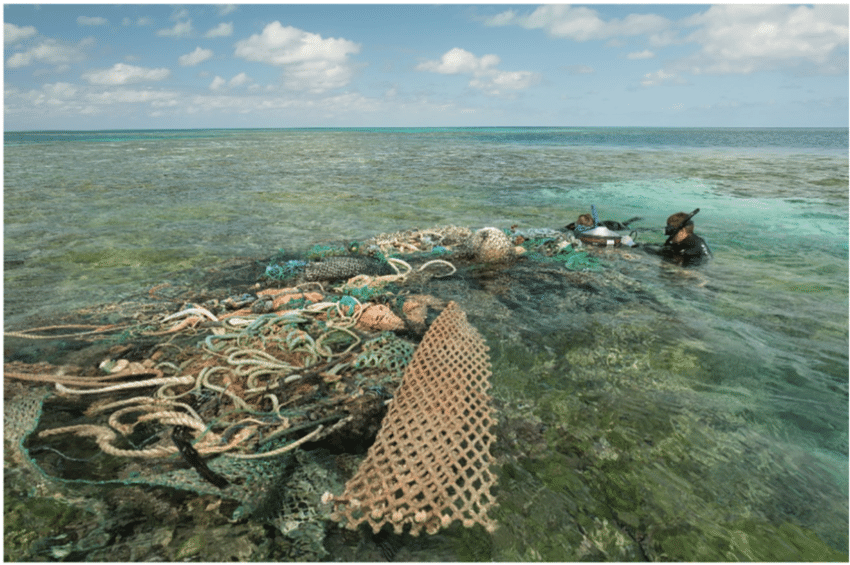 Divers attach a satellite buoy to a derelict fishing net conglomerate